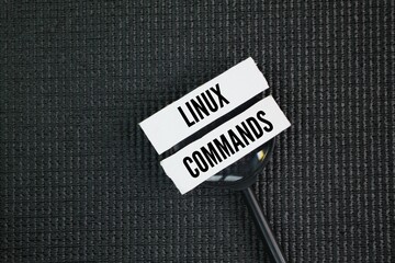 A magnifying glass with the words Linux commands. instructions that users input into a terminal to...