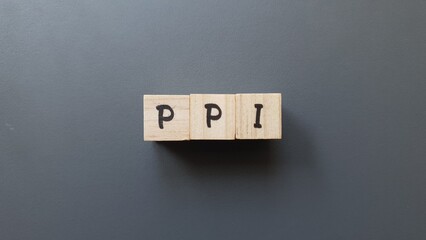 PPI acronym made of wooden letter cubes on dark background. Plan de Previsión Individual...