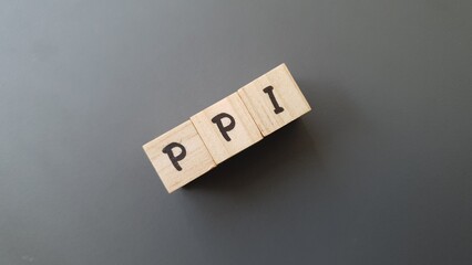 PPI acronym made of wooden letter cubes on dark background. Plan de Previsión Individual...