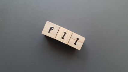 FII acronym made of wooden letter cubes on dark background. Fondo de Inversión Inmobiliaria (Real...