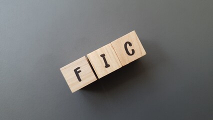 FIC acronym made of wooden letter cubes on dark background. Fondo de Inversión Colectiva (Collective Investment Fund)