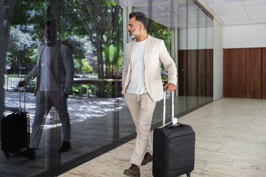 Indian man with suitcase explores modern urban landscape