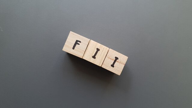 FII acronym made of wooden letter cubes on dark background. Fondo de Inversi&oacute;n Inmobiliaria (Real Estate Investment Fund)
