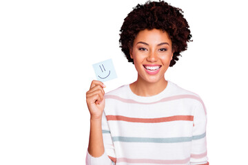 Photo of cheerful cute nice fascinating youngster smiling toothily wearing white striped sweater holding piece of paper with emoji on isolated pink color background pastel