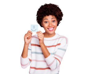 Photo of cheerful charming cute nice girlfriend black skinned holding piece of paper with emoji drawed on wearing white striped sweater isolated over pastel pink color background