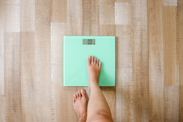 Overhead View Of Bare Feet Stepping Into Digital Scale