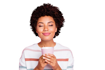 Photo of pretty dark skin lady holding in hands hot beverage cup dreamy closing eyes enjoy good...