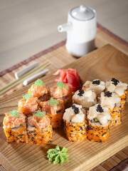 A plate of sushi with a white sauce and a small white bowl of sauce