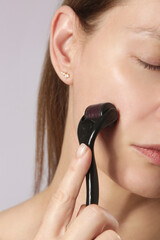 Facial massage with microneedle dermaroller for the treatment of scars, wrinkles and for facial...