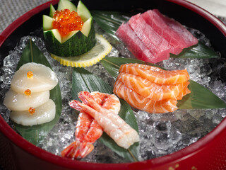 A bowl of sushi with a variety of fish and vegetables
