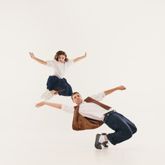 Dynamic lindy hop dancers in mid-air showcase vintage flair with energetic retro dance moves....
