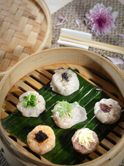 A variety of dumplings are displayed in a bamboo basket