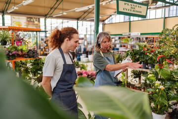 Entrepreneur and employee discussing plants in a greenhouse