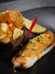 A plate of food with a fish and chips and a lemon wedge