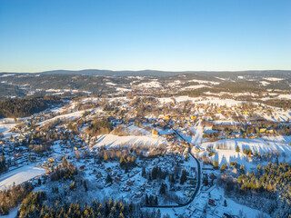 A breathtaking winter view of Nova Ves nad Nisou surrounded by snow-covered landscapes. The sunset...