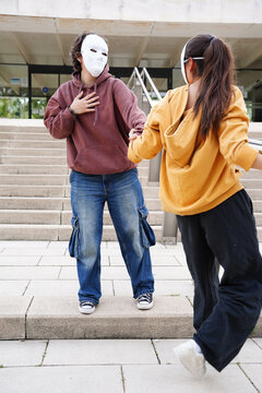 Teenagers in drama class performing with masks