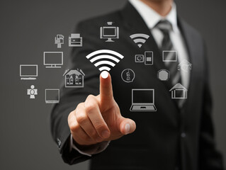 Businessman touching wireless network connection with smart home and office devices icons on gray background