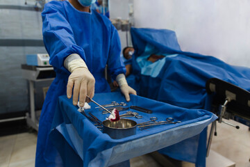 Surgical team performing a medical procedure in an operating room with various surgical instruments.
