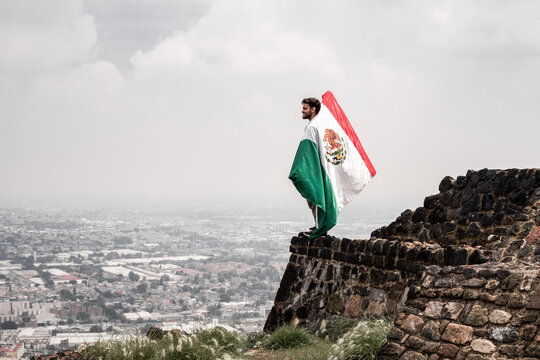 Man with Mexican flag at ancient archaeological site