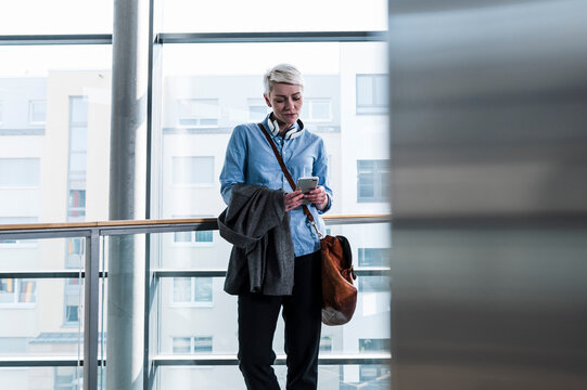 Businesswoman in office checking mobile phone