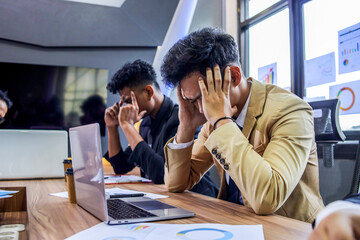 Troubled Businessman Sitting at Table and Holding Head, Worried of Company Problem