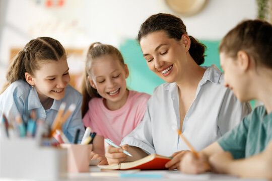 Happy kids and teacher at school - Powered by Adobe