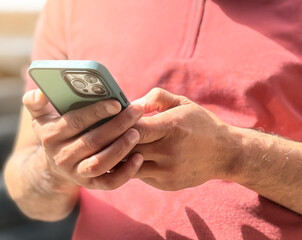 A man checking social media, texting on his smartphone to friends. Close-up image of a man using his smartphone, playing a mobile game or watching a video online while relaxing. People and technology.