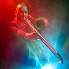 A jazz musician passionately plays the trombone under vibrant stage lighting and fog effects....