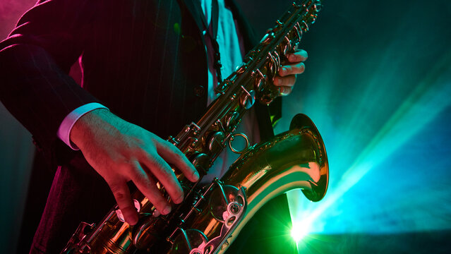 A jazz musician passionately performs with a saxophone under vibrant stage lights. Concept of musical artistry in a lively atmosphere.