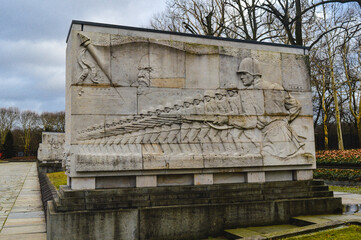 Stone relief wall at Treptower Park, Berlin, depicting Soviet soldiers marching with rifles, part...