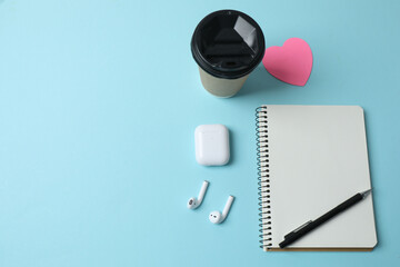 blank notepad with clock, alarm clock and pen on blue pastel pink background.
