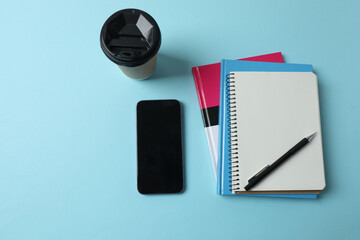 blank notepad with clock, alarm clock and pen on blue pastel pink background.