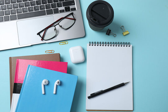 laptop glasses coffee headphones notepad on a blue background with space for text