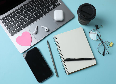 laptop glasses coffee headphones notepad on a blue background with space for text - Powered by Adobe