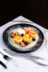 Syrniki cheese pancakes with vanilla sauce, berries and ice cream