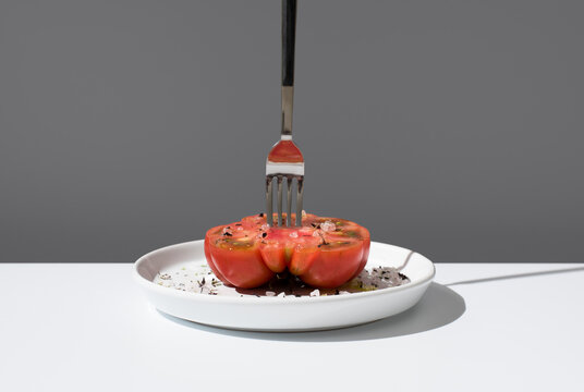 Raf tomato with salt and spices on a white plate