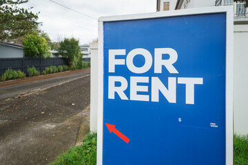 House For Rent real estate sign. Arrow sign pointing the house at the back of driveway.