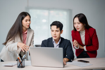 Asian businesspeople discussing and working together using laptop computer analyzing financial data...