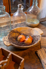 Pumpkins resting in wooden bowl with glass bottles and rustic wooden box in Heimschuh, Styria