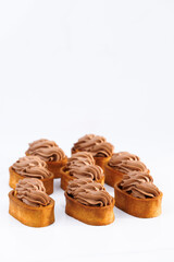 Tasty dessert. Dessert of dough, nut tartlets covered with a layer of caramel. Tartlet with caramelized nuts isolated on white. Caramel tartlet, caramelized peanuts, salted caramel, chocolate ganache