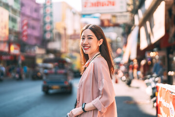 Beautiful smiling face young adult asian woman traveler in urban city with digital camera walking tour staycation outdoor on day