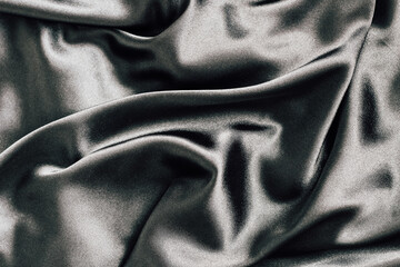 Silky black fabric draped elegantly on a surface with soft lighting and rich texture