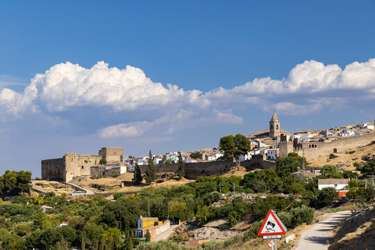Sabiote cityscape featuring the castle, church, and fortified walls under a cloudy sky in Andalusia, Spain