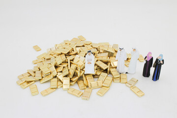 Group of Figurines Standing Beside a Pile of Gold Bars