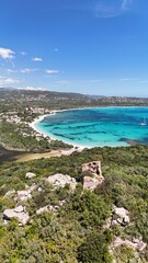 Vue a&eacute;rienne de la baie de Saint Cyprien en Corse, avec ses eaux turquoise, sa plage et les ruines d&rsquo;une tour g&eacute;noise au premier plan.