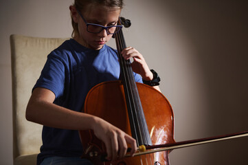 Young Musician Practicing Playing the Cello in a Quiet Setting