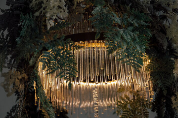 Elegant chandelier adorned with greenery creates an enchanting atmosphere in a modern space