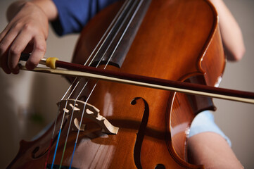 Hands Playing a Cello Using a Bow, Highlighting Music Performance