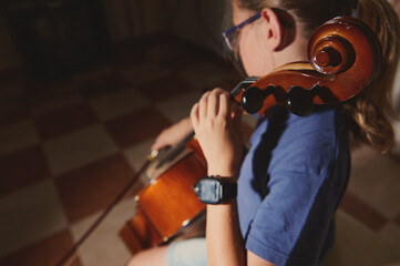 Close-Up of a Young Musician Playing the Cello in a Sunlit Room