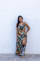 Brunette woman on a white background wearing a summer dress.